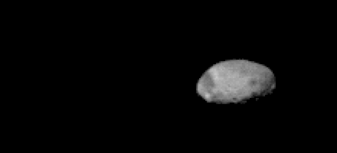 A small, potato-shaped, pale gray rock drifts in black space.