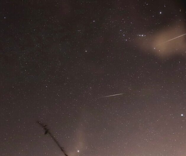 Starry sky with 2 streaks on the right side. There are some light clouds, and 3 bright dots on the top right.