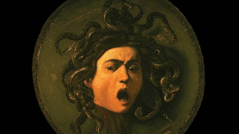 Painting of the head of dead Medusa with snakes in place of hair and wide-open mouth.