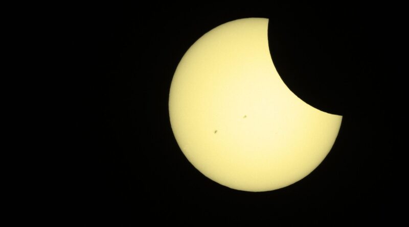 Yellow sphere with the top right blocked by a black figure. There are 2 black dots on the yellow sphere.