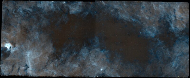 Milky Way's center: An irregular dark shape with some bluish tinges on the edges and white filaments farther out.