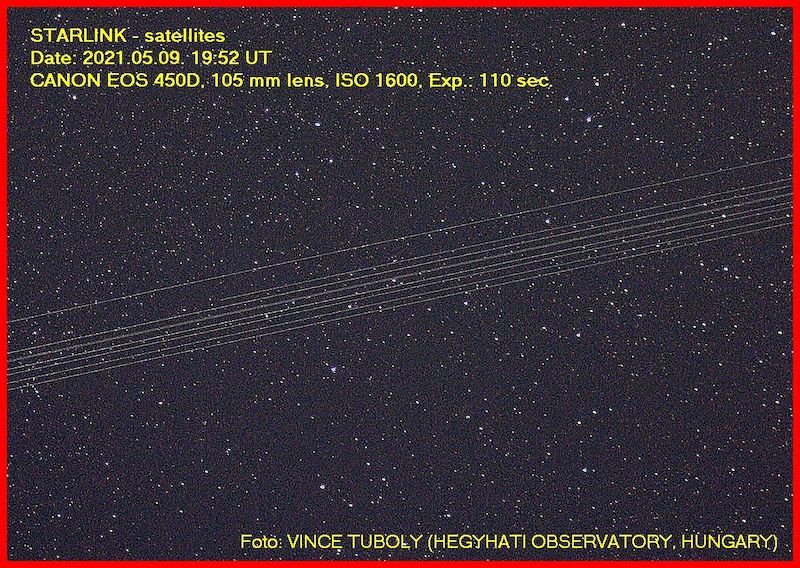 Numerous thin, parallel white lines cross a starry night sky, covering stars in its background.