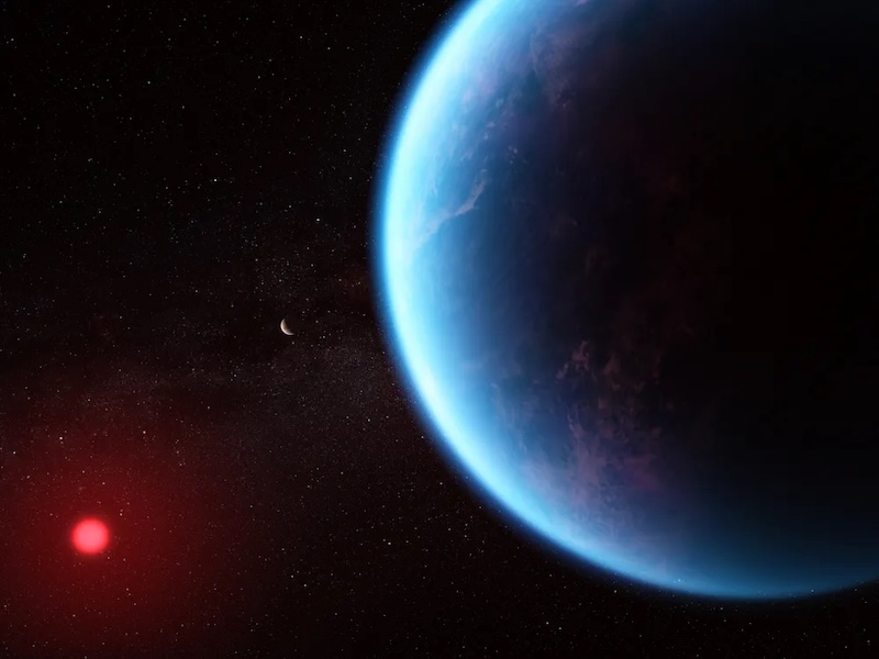 Haze on water worlds: Blue-colored planet with water ocean and navy clouds in its atmosphere, with reddish star in background.