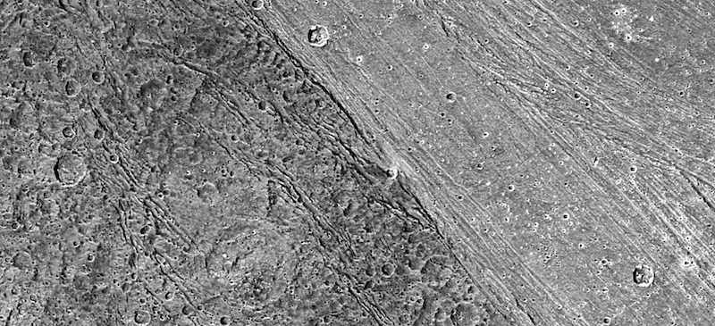 Darker cratered terrain left, with brighter and less-cratered terrain on right, and a sharp boundary between them.